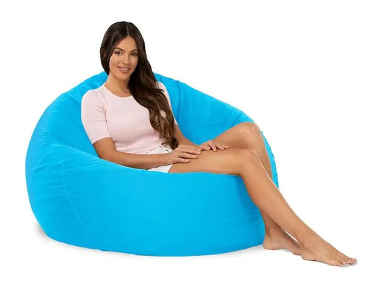 Woman sitting on a large blue bean bag chair against a white background
