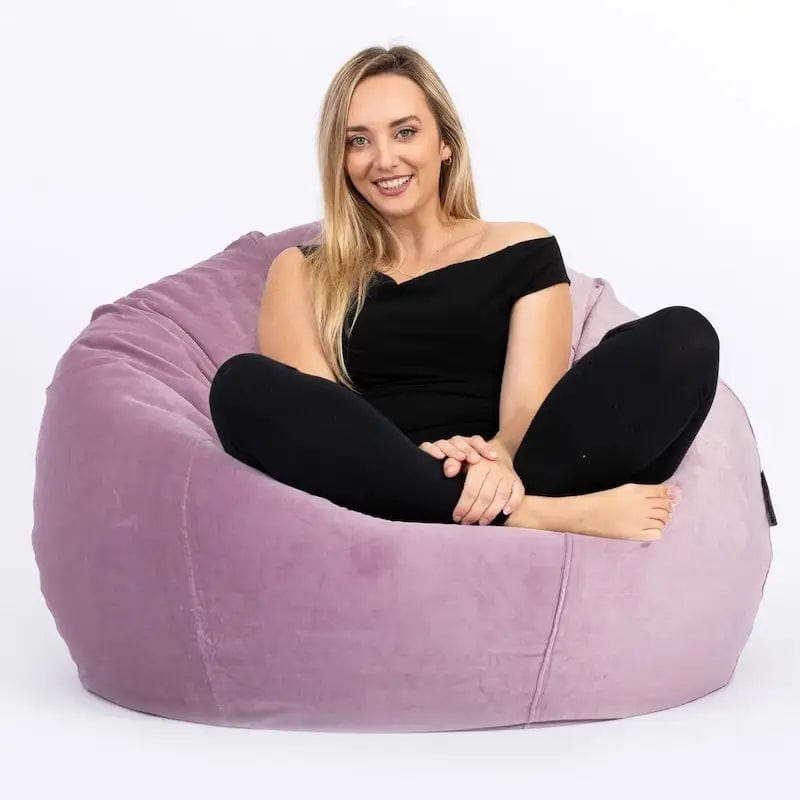 Woman sitting on a purple bean bag chair against a white background