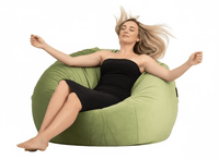 Woman relaxing on a green bean bag chair against a white background