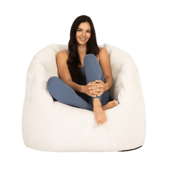Woman sitting in a white bean bag chair on a white background