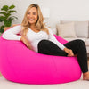 Woman sitting on a pink bean bag chair in a living room.