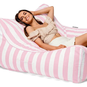 Woman lying on a pink and white striped bean bag chair