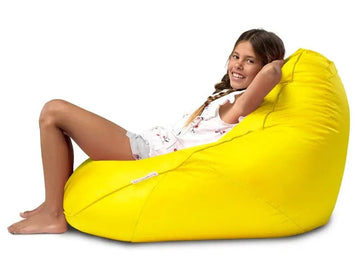 Young girl sitting on a yellow bean bag chair against a white background