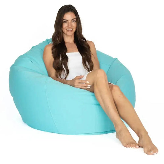 Woman sitting on a large turquoise bean bag chair against a white background